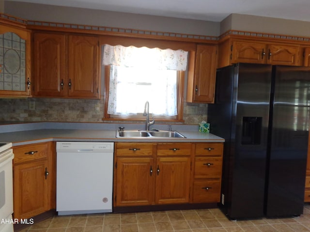 kitchen featuring a sink, brown cabinets, white dishwasher, and black refrigerator with ice dispenser