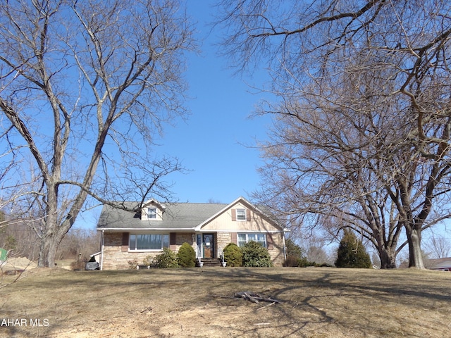 view of front of house featuring stone siding and a front lawn