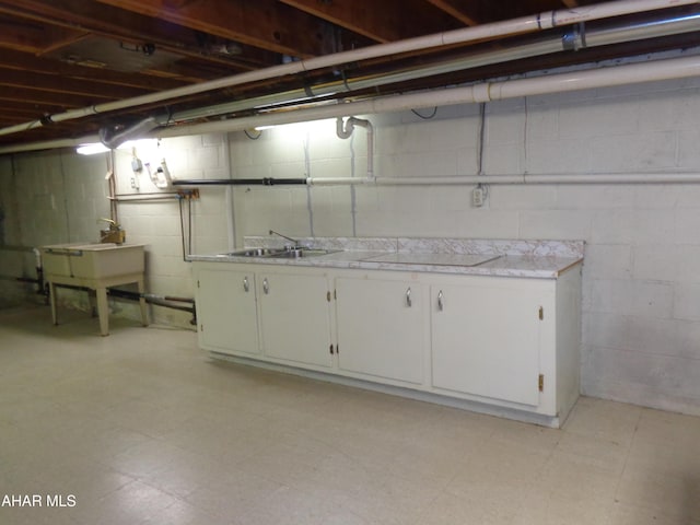 unfinished basement with light floors and a sink