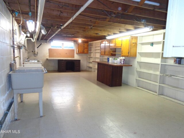 basement with tile patterned floors and a sink