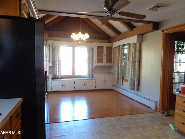 kitchen featuring visible vents, lofted ceiling with beams, a baseboard heating unit, freestanding refrigerator, and glass insert cabinets