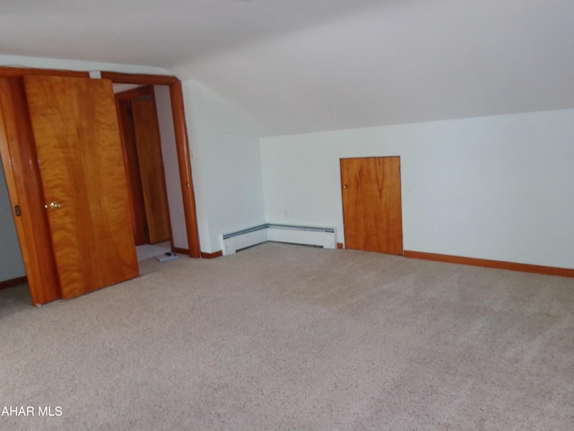 additional living space featuring carpet floors, a baseboard heating unit, baseboards, and vaulted ceiling