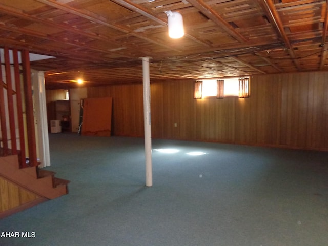 below grade area with stairway, wood walls, and carpet flooring