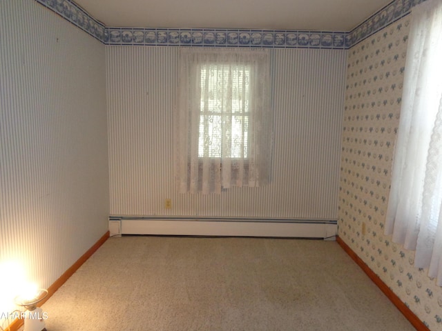 empty room featuring baseboards, wallpapered walls, a baseboard heating unit, and carpet