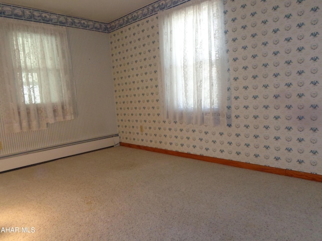 empty room with a baseboard heating unit and baseboards