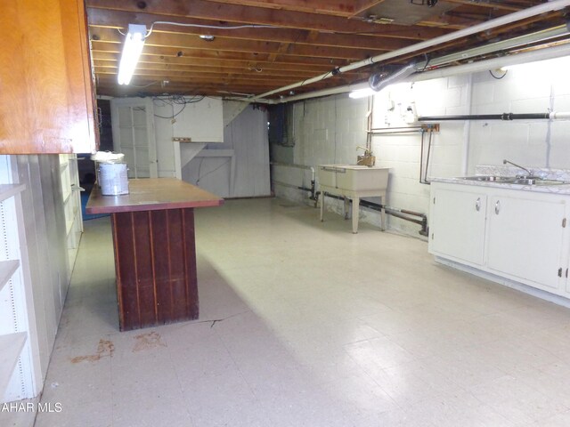 unfinished basement with light floors and a sink