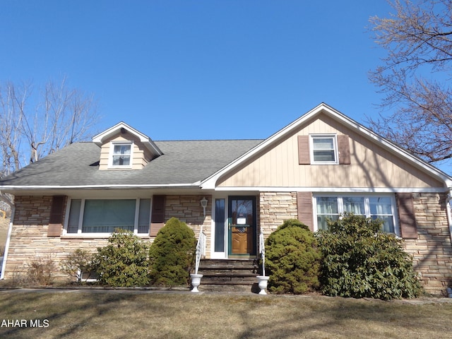 view of front facade featuring stone siding and a shingled roof