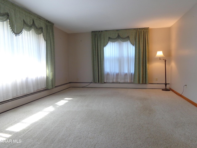 spare room featuring carpet flooring, a healthy amount of sunlight, and baseboards