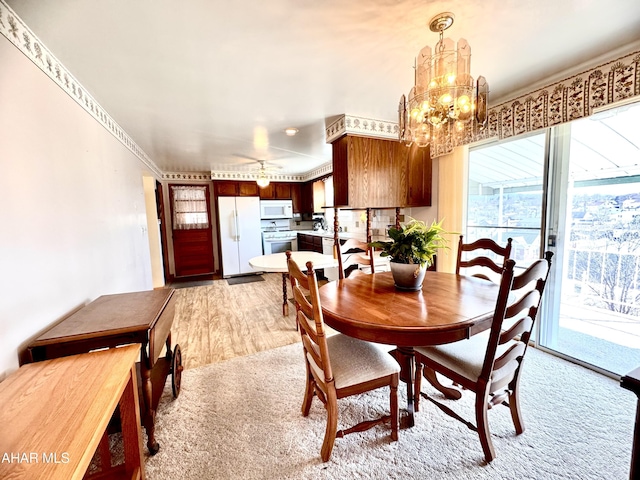 dining space featuring light wood finished floors and a chandelier