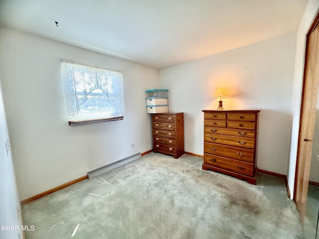 carpeted bedroom featuring a baseboard heating unit and baseboards