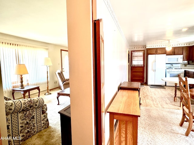 kitchen featuring white appliances and light carpet