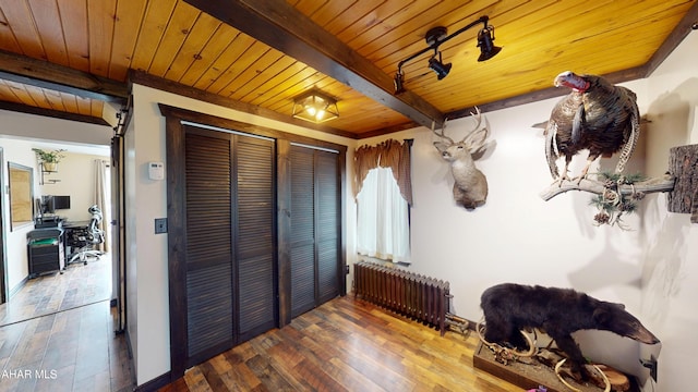 interior space featuring beamed ceiling, radiator heating unit, wood ceiling, and wood-type flooring