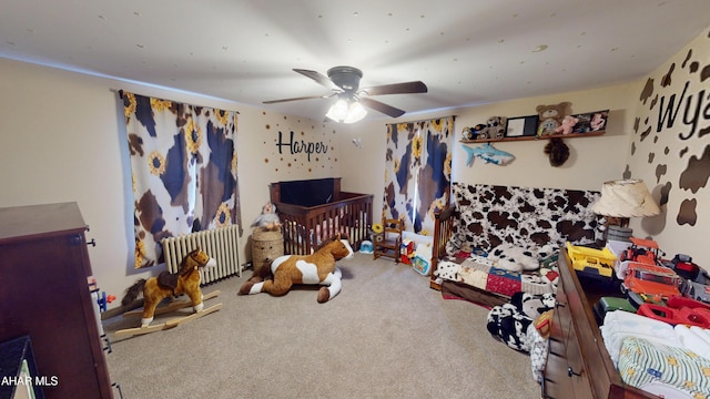 bedroom with carpet flooring, ceiling fan, and radiator heating unit