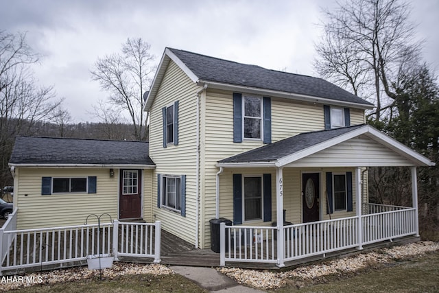 view of front facade with covered porch and roof with shingles