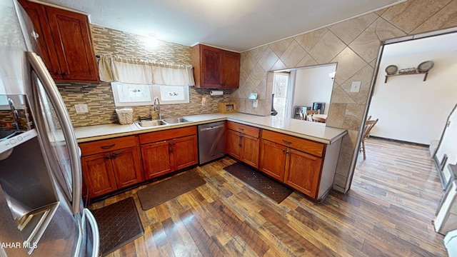 kitchen featuring dark wood-style flooring, appliances with stainless steel finishes, light countertops, and a sink