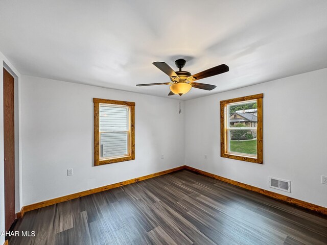 spare room with ceiling fan and dark wood-type flooring