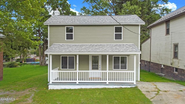 view of front property featuring a front yard, a porch, and a trampoline