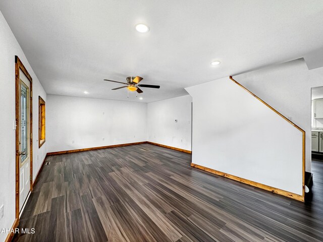 unfurnished living room with dark hardwood / wood-style flooring and ceiling fan