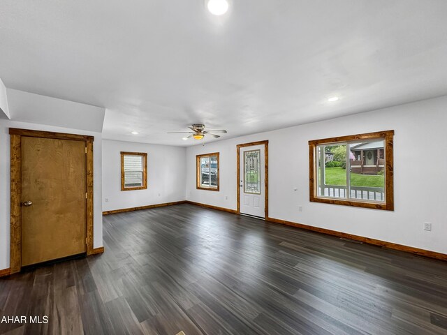 unfurnished room with ceiling fan and dark wood-type flooring