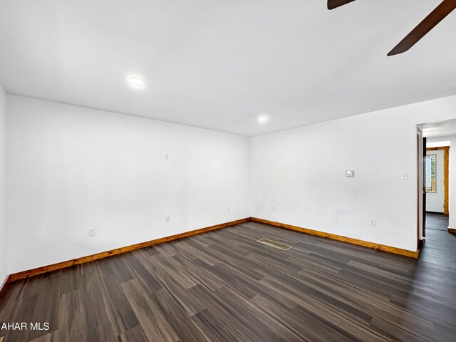 spare room featuring ceiling fan and dark wood-type flooring