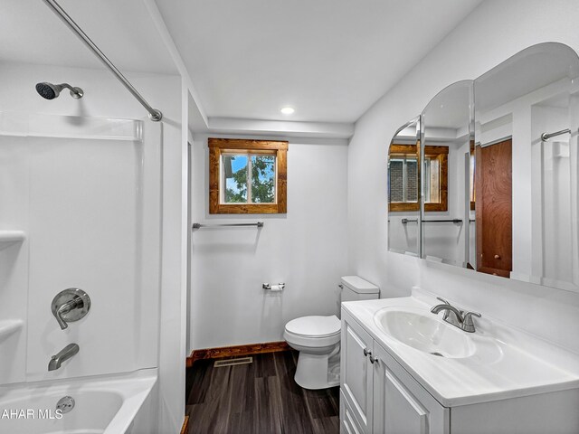 full bathroom with hardwood / wood-style floors, vanity, toilet, and shower / washtub combination