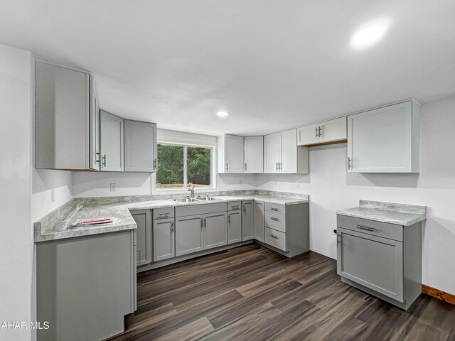 kitchen featuring gray cabinets, dark wood-type flooring, and sink