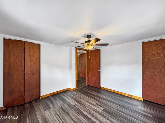 unfurnished bedroom with dark hardwood / wood-style flooring and ceiling fan