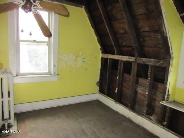 additional living space with ceiling fan, wood finished floors, radiator, and baseboards