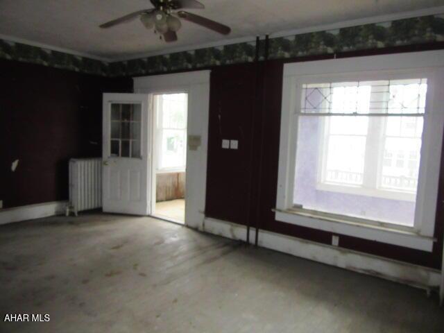 spare room with radiator heating unit and a ceiling fan