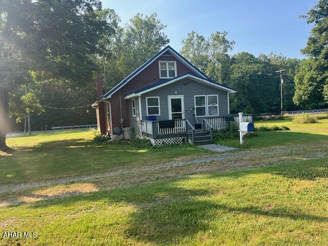 6331 Hyndaman Rd, Buffalo Mills, PA 15534 - bungalow-style home featuring a front yard, a wooden deck, and a chimney