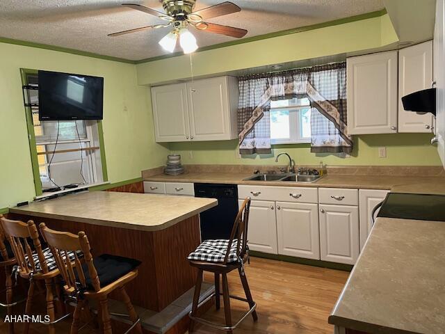 6331 Hyndaman Rd, Buffalo Mills, PA 15534 - kitchen featuring black dishwasher, a kitchen breakfast bar, a textured ceiling, white cabinetry, and extractor fan
