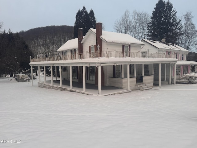 view of snow covered back of property