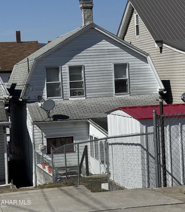 exterior space with a gambrel roof and fence