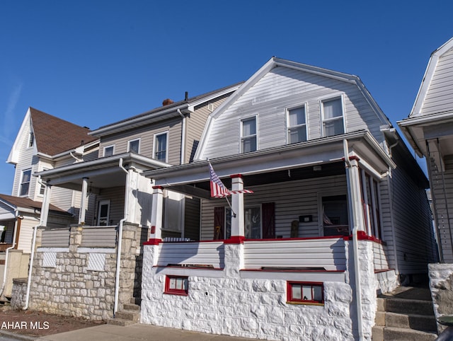 view of front of home featuring a gambrel roof and a porch