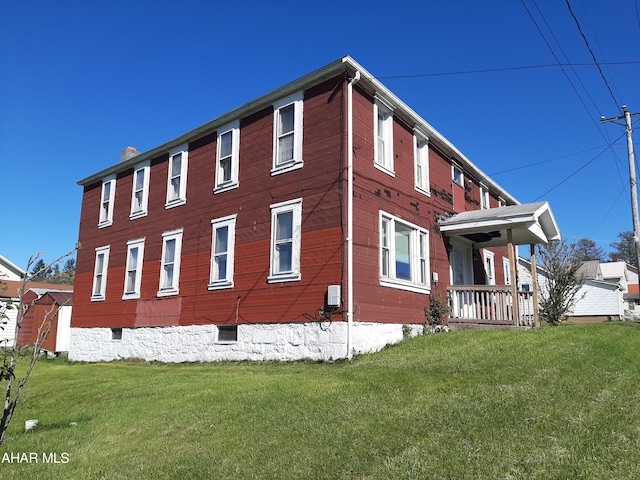 view of property exterior featuring a porch and a lawn