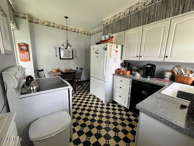 522 Wayne St, Hollidaysburg, PA 16648 - kitchen featuring freestanding refrigerator, dark flooring, white cabinets, washer / clothes dryer, and pendant lighting