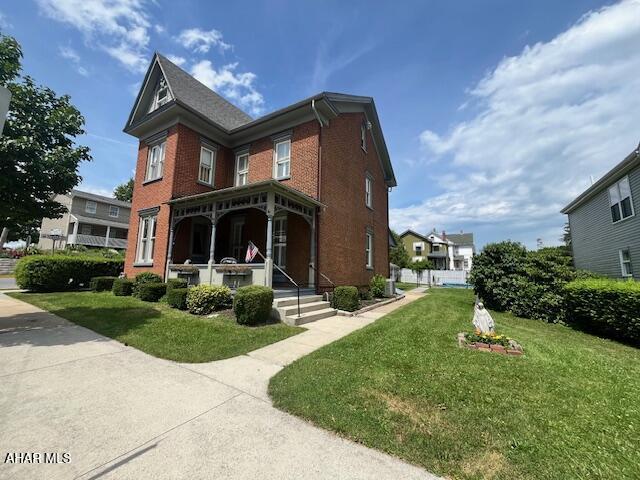 522 Wayne St, Hollidaysburg, PA 16648 - view of front of home featuring brick siding, a front yard, and a porch