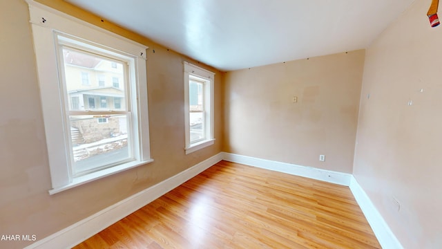 spare room featuring plenty of natural light and light hardwood / wood-style flooring