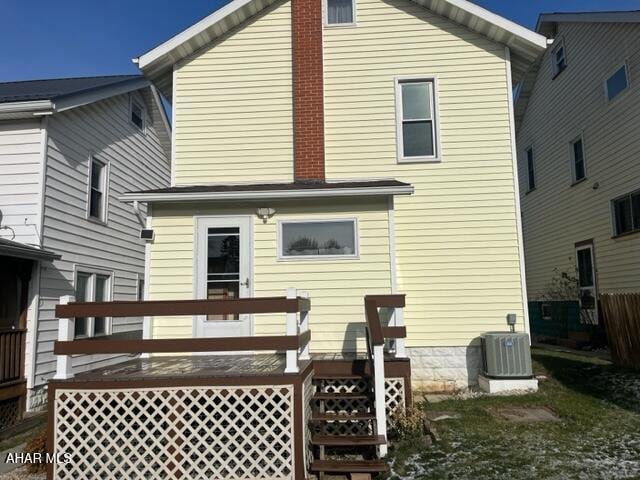 rear view of house featuring cooling unit and a wooden deck