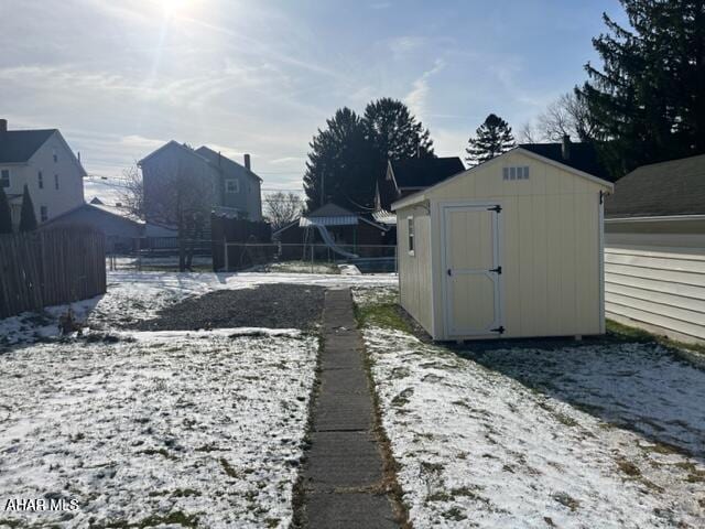 yard layered in snow featuring a shed