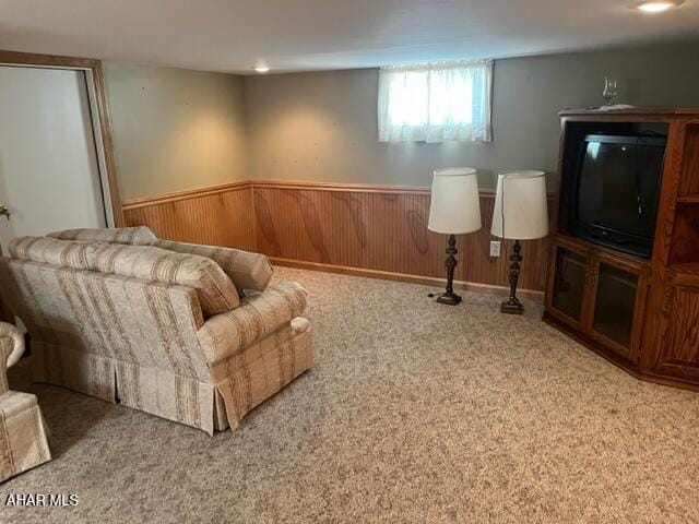 living room with carpet flooring and wood walls