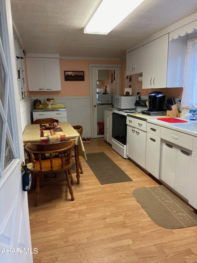 kitchen with white cabinets, light hardwood / wood-style floors, and white appliances