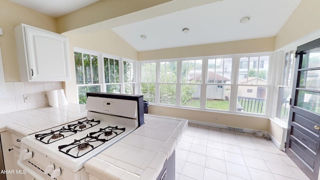 1113 Broadway, Altoona, PA 16601 - kitchen featuring white range with gas cooktop, tile countertops, lofted ceiling, and plenty of natural light