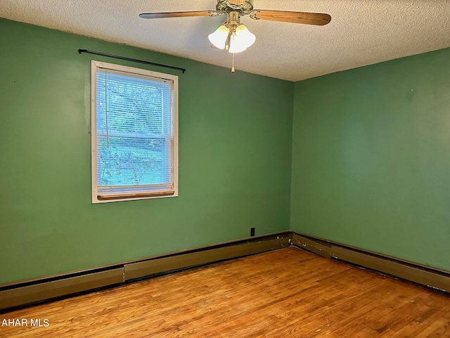 spare room with a textured ceiling, light hardwood / wood-style flooring, ceiling fan, and a baseboard heating unit