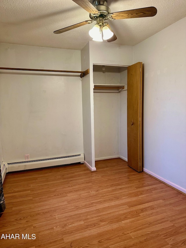 unfurnished bedroom featuring a textured ceiling, light hardwood / wood-style floors, baseboard heating, and ceiling fan