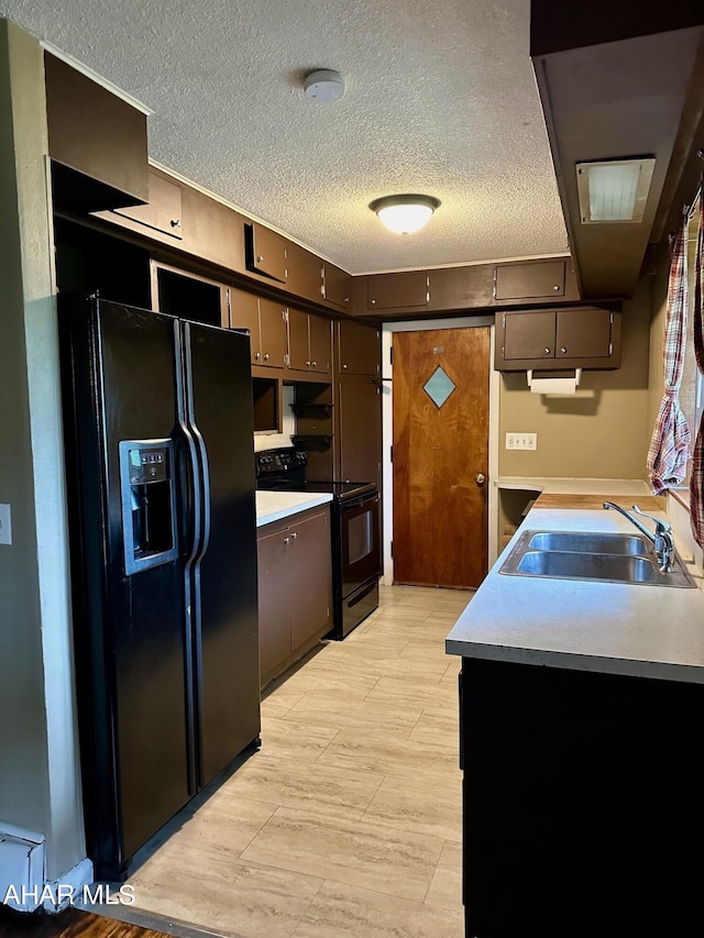 kitchen featuring black appliances, dark brown cabinets, sink, and a textured ceiling