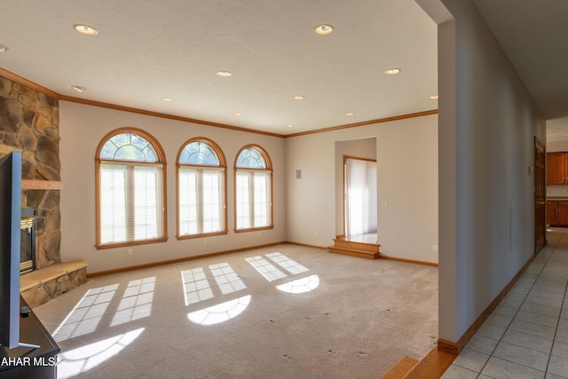 219 Scenic Pine Dr, Hollidaysburg, PA 16648 - unfurnished living room with crown molding, plenty of natural light, baseboards, light carpet, and a stone fireplace