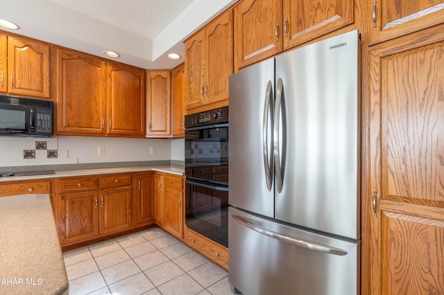 219 Scenic Pine Dr, Hollidaysburg, PA 16648 - kitchen with black appliances, recessed lighting, brown cabinetry, tasteful backsplash, and light countertops