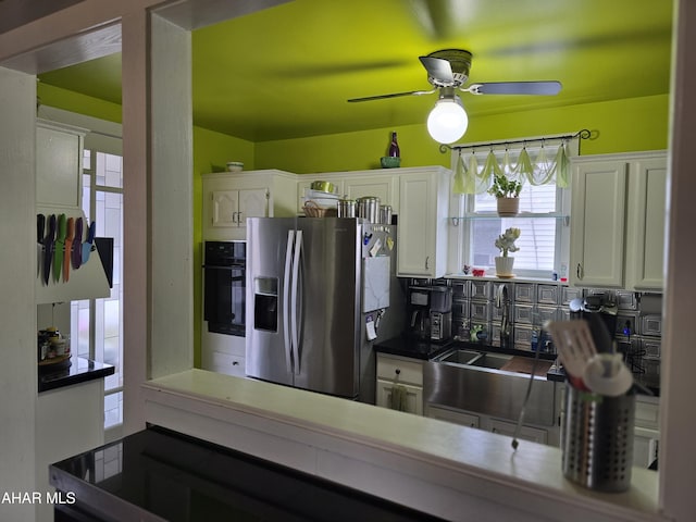 kitchen featuring oven, a ceiling fan, white cabinets, and stainless steel refrigerator with ice dispenser