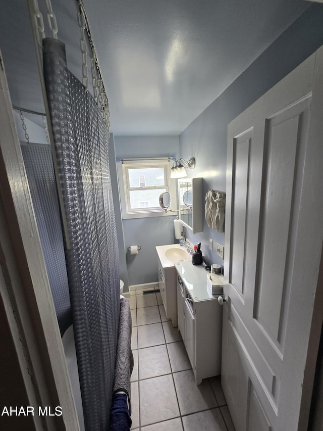 full bath featuring tile patterned flooring, curtained shower, toilet, and vanity